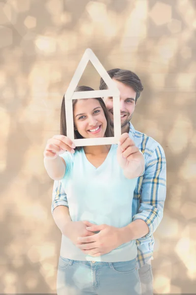 Happy young couple with house shape — Stock Photo, Image