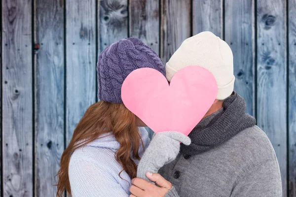 Couple in warm clothing holding heart — Stock Photo, Image