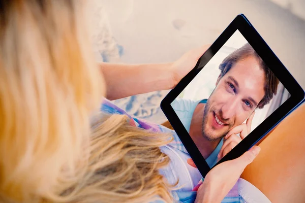 Mujer usando tableta con el hombre mirando a la cámara — Foto de Stock