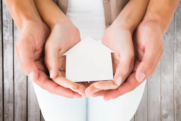 Casal segurando casa em miniatura nas mãos — Fotografia de Stock