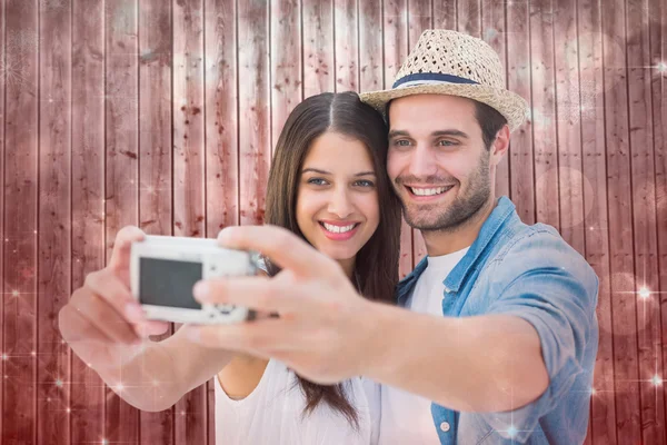 Imagen compuesta de feliz pareja hipster tomando una selfie — Foto de Stock