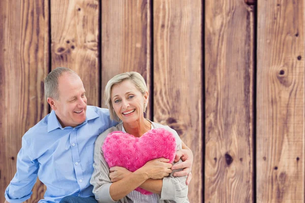 Šťastný starší pár s polštář srdce — Stock fotografie
