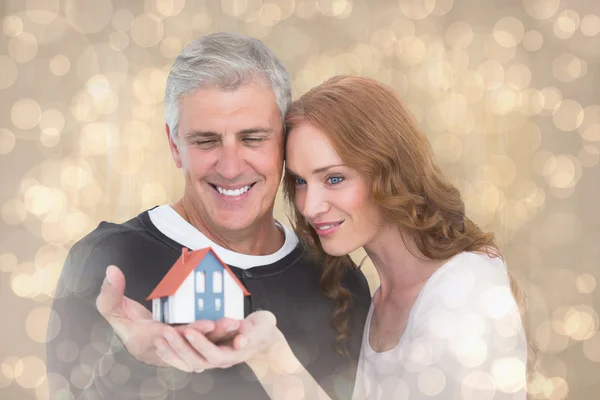 Casual couple holding small house — Stock Photo, Image