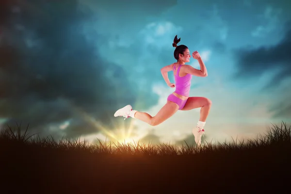 Passende kvinne som løper og hopper – stockfoto