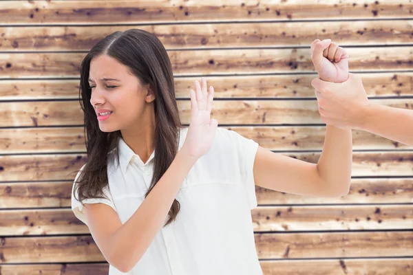 Fearful brunette being grabbed by the hand — Stock Photo, Image