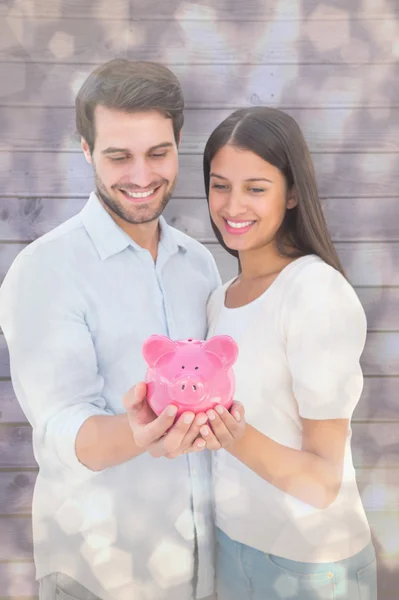 Casal segurando seu banco porquinho — Fotografia de Stock