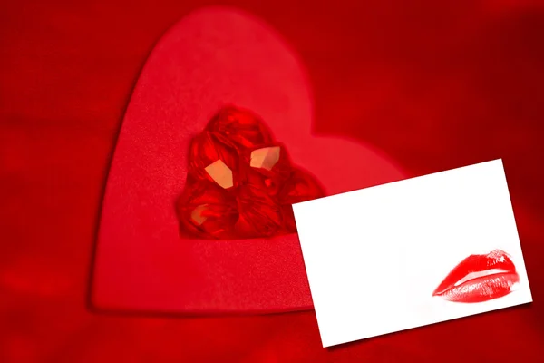 Rubies and paper red heart against card — Stock Photo, Image