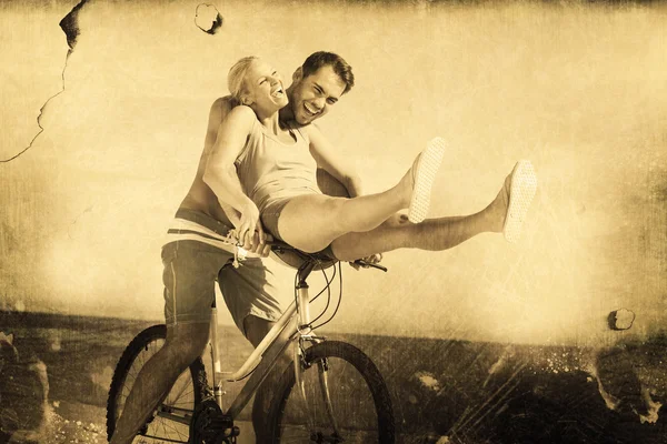 Happy man giving girlfriend a lift on his crossbar — Stock Photo, Image