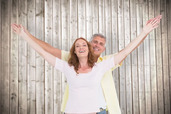 Casal sorrindo com os braços levantados — Fotografia de Stock