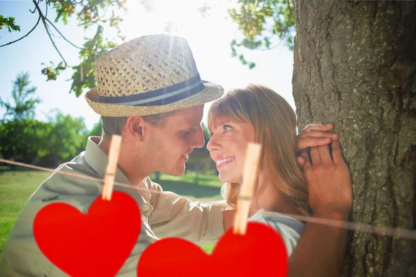 Couple leaning against tree in the park — Stock Photo, Image