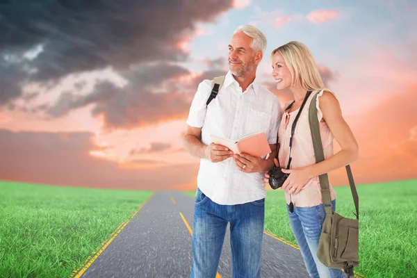 Happy tourist couple using the guidebook — Stock Photo, Image