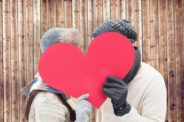 Pareja en ropa de abrigo sosteniendo corazón rojo —  Fotos de Stock