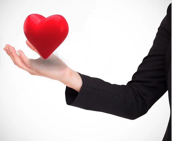 Businesswomans arm presenting heart — Stock Photo, Image