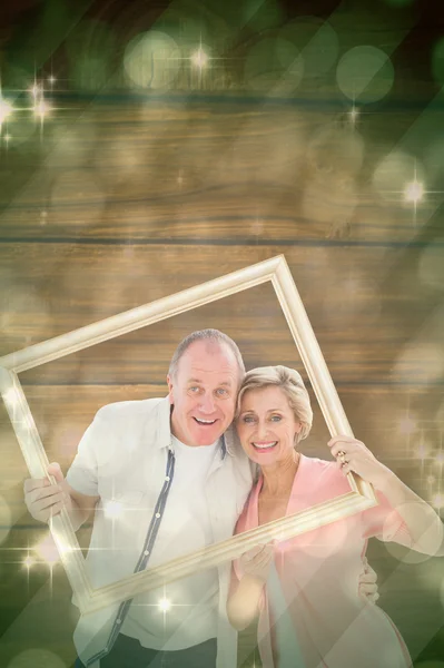 Paar lächelt durch Bilderrahmen in die Kamera — Stockfoto