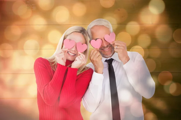 Fåniga par hålla hjärtan över deras ögon — Stockfoto