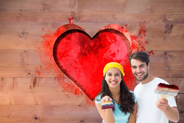 Pareja pintando juntos contra el corazón rojo — Foto de Stock