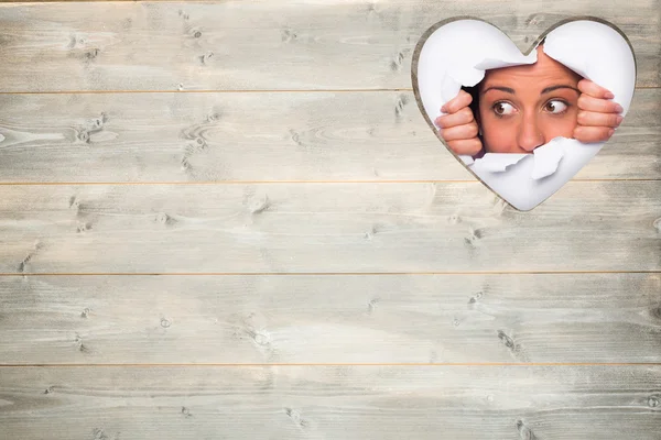 Jonge vrouw op zoek via papier rip — Stockfoto