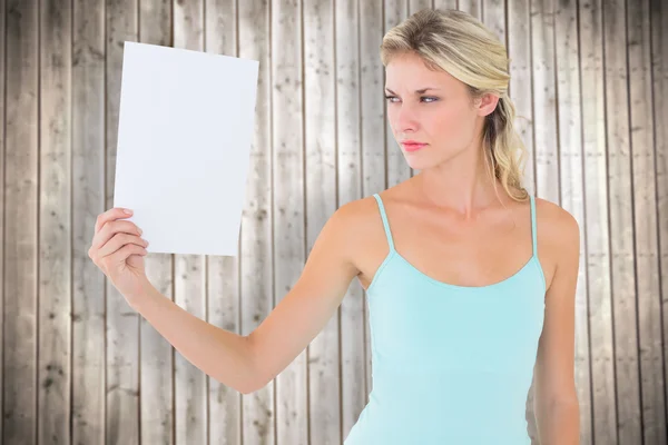 Wütende Blondine hält ein Blatt Papier in der Hand — Stockfoto