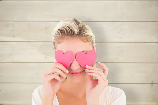 Blonde holding hearts over eyes — Stock Photo, Image