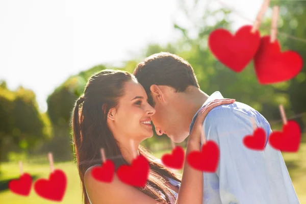 Счастливая пара в парке против сердец — стоковое фото