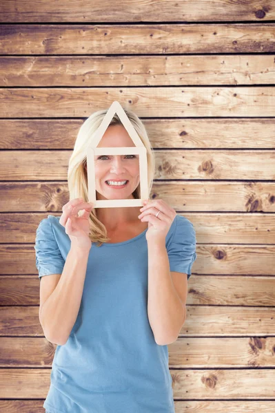 Blonde holding house outline over face — Stock Photo, Image