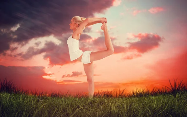 Mulher alongando o corpo enquanto se equilibra — Fotografia de Stock