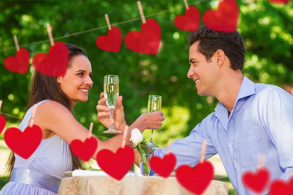 Couple with champagne flutes sitting at outdoor — Stock Photo, Image