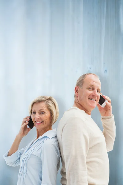 Feliz pareja madura hablando en sus teléfonos —  Fotos de Stock