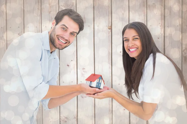 Casal segurando uma casa modelo — Fotografia de Stock