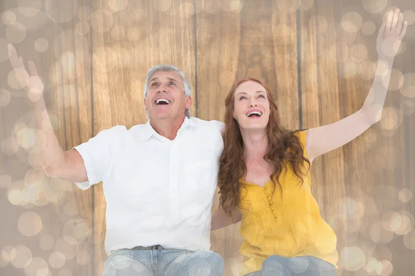 Casal sorrindo com os braços levantados — Fotografia de Stock