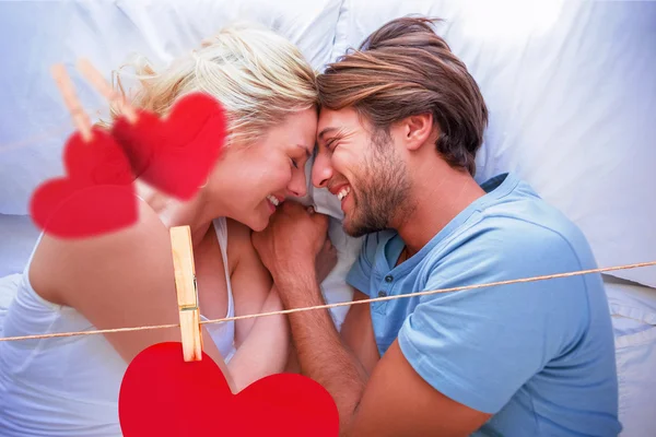 Couple relaxing on bed smiling at each other — Stock Photo, Image