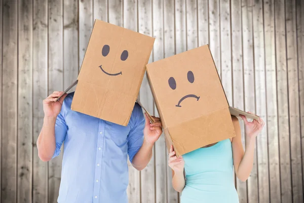 Couple portant des boîtes de visage triste sur la tête — Photo