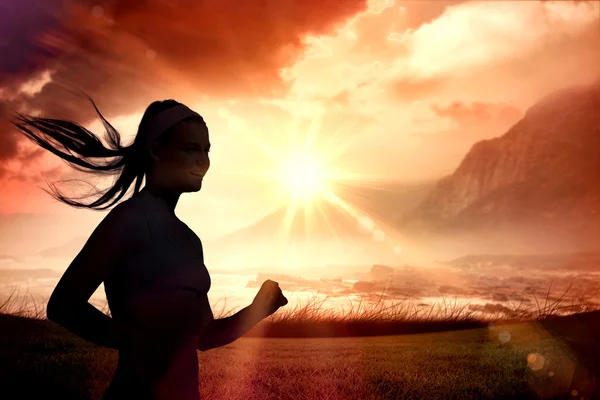 Woman jogging  against sunrise over magical sea — Stock Photo, Image