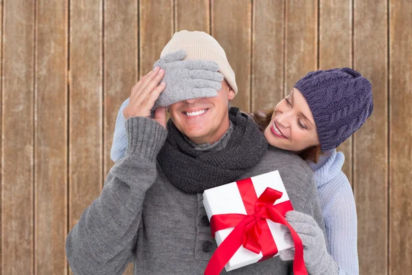 Woman surprising husband with gift — Stock Photo, Image