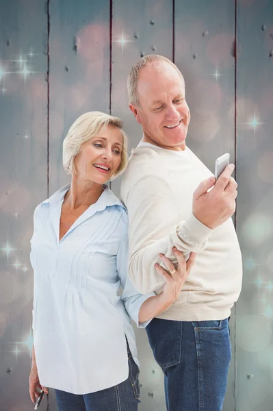 Couple mature regardant smartphone ensemble — Photo