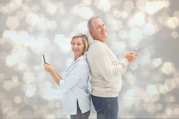 Pareja madura usando sus teléfonos inteligentes — Foto de Stock