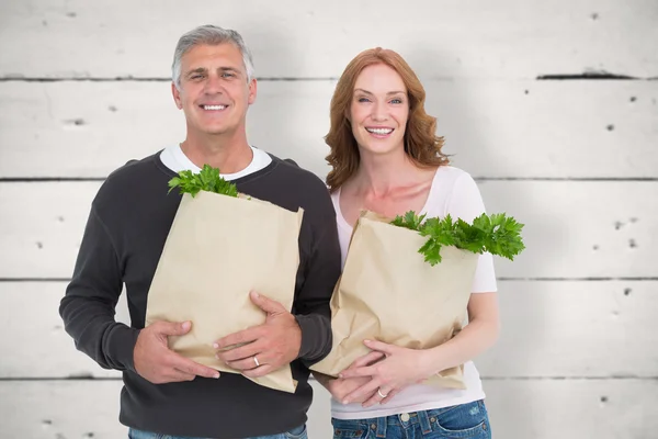 Pareja casual sosteniendo bolsas de comestibles —  Fotos de Stock