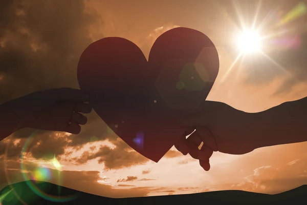 Pareja pasando un corazón de papel — Foto de Stock