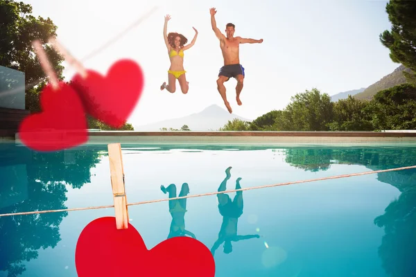 Casal pulando na piscina — Fotografia de Stock