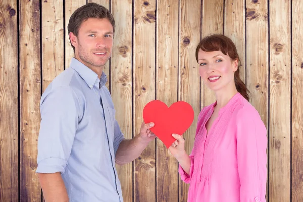 Casal segurando um coração vermelho — Fotografia de Stock