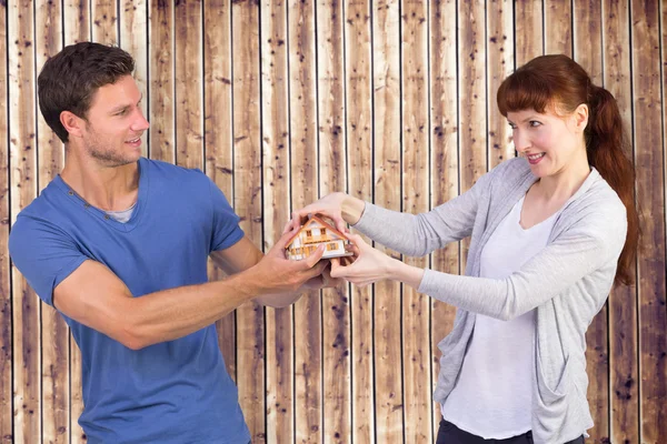 Casal puxando uma casa modelo — Fotografia de Stock