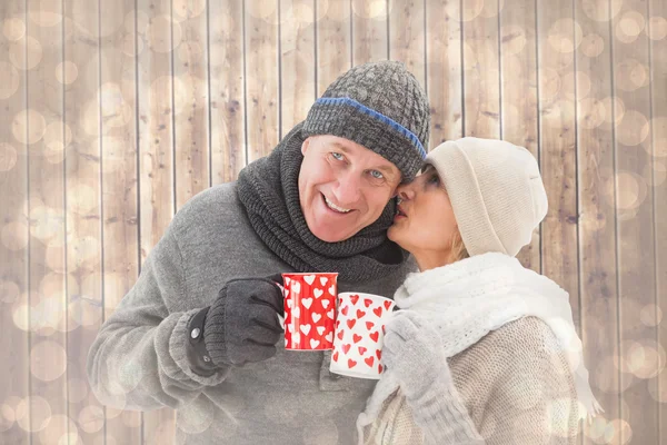 Casal em roupas de inverno segurando canecas — Fotografia de Stock