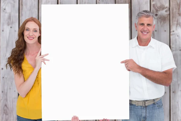 Pareja casual mostrando un póster — Foto de Stock