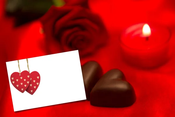 Червона троянда свічка і шоколадні серця — стокове фото
