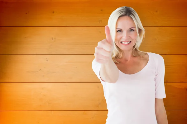 Blondine zeigt Daumen nach oben gegen Holzplanken — Stockfoto