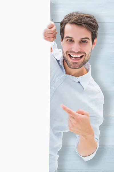 Young man smiling and holding poster — Stock Photo, Image