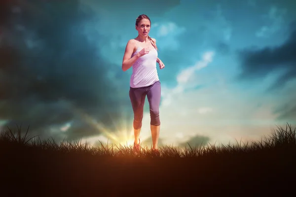 Fit blonde jogging over grass — Stock Photo, Image