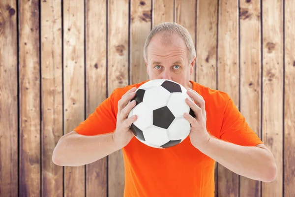 Нервный футбольный болельщик держит мяч — стоковое фото