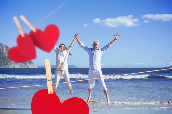 Paar springt barfuß am Strand hoch — Stockfoto