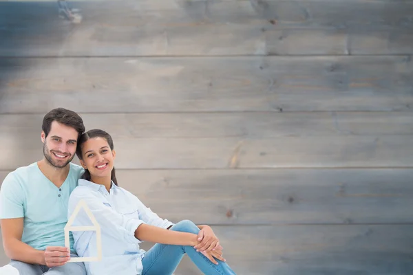 Couple sitting holding a house shape — Stock Photo, Image